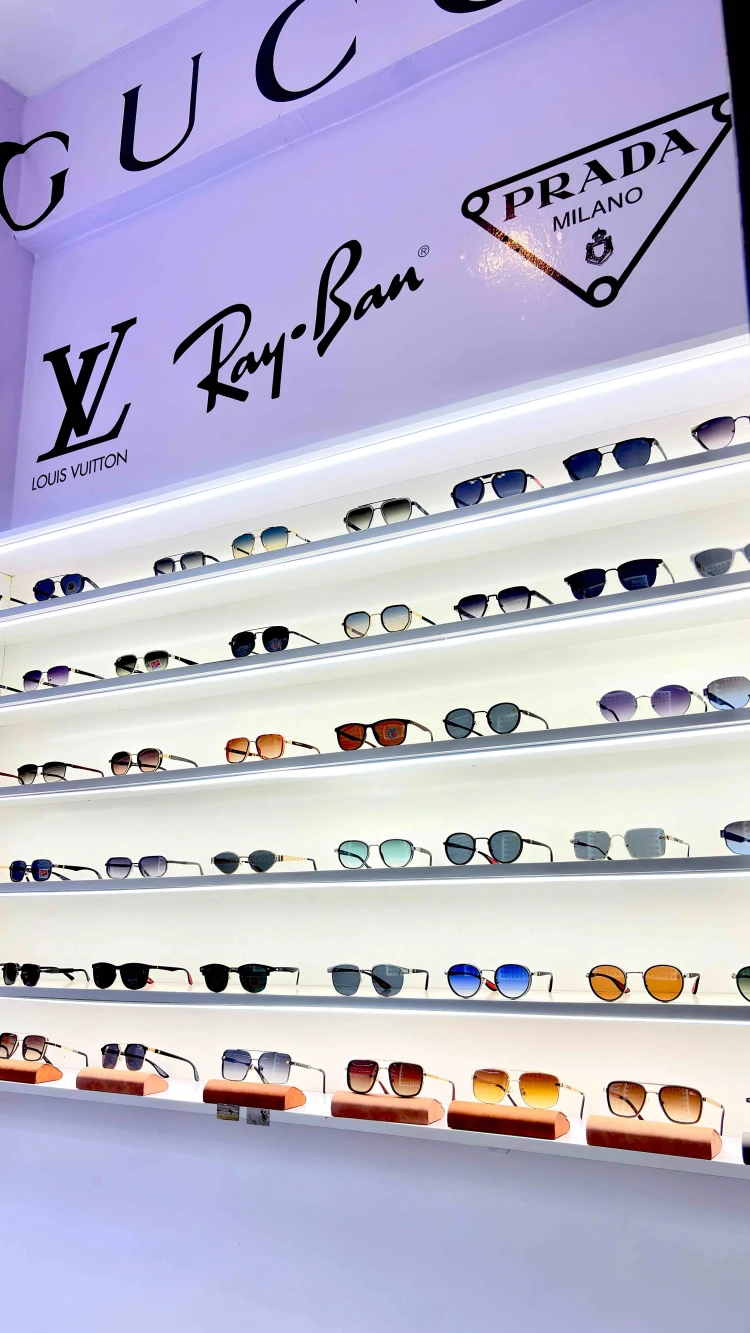 The shop's lit wall of sunglasses, row above row