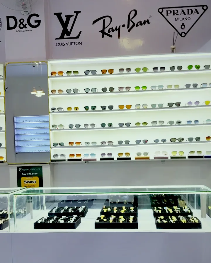 The sunglasses wall inside the Oluxy boutique at GF Plaza, lit shelves of frames above glass counters